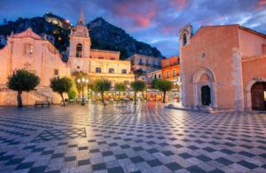 Main square Piazza IX Aprile and San Giuseppe church at sunset, image by Rudy Balasko, shutterstock